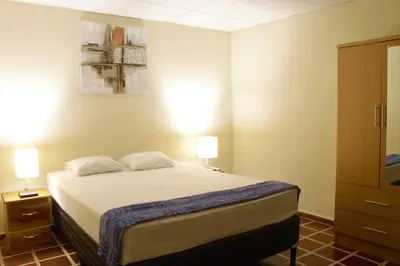 a bedroom with a bed and two lamps and a dresser at Casa Central completa in Santa Ana