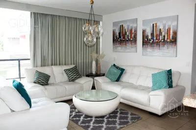 a living room with white couches and a coffee table at The Luxury Apartment in San Salvador