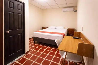 a room with a bed and a desk and a table at Casa Central de Santa Ana in Santa Ana