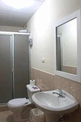 a bathroom with a sink and a toilet and a mirror at Casa Central de Santa Ana in Santa Ana