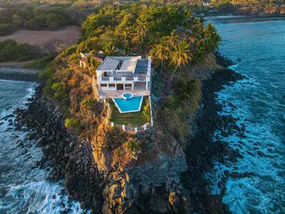 an aerial view of a house on an island in the water at Paradise Surf Hotel in San Miguel