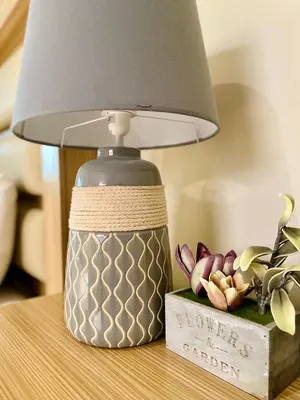 a lamp sitting on a table next to a flower arrangement at Paradise Surf Hotel in San Miguel