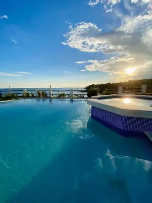 a large swimming pool with a view of the ocean at Paradise Surf Hotel in San Miguel