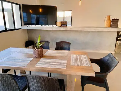 a wooden table with chairs and a counter at Paradise Surf Hotel in San Miguel