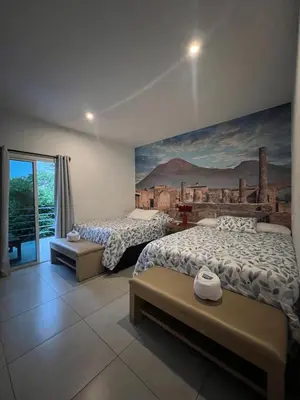 a bedroom with two beds and a painting on the wall at VILLA NAPOLI in Santa Ana