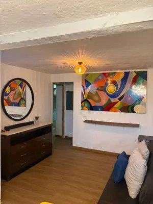 a living room with a painting on the wall at VILLA NAPOLI in Santa Ana