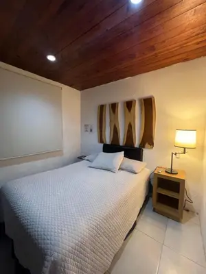 a bedroom with a bed and a table with a lamp at VILLA NAPOLI in Santa Ana