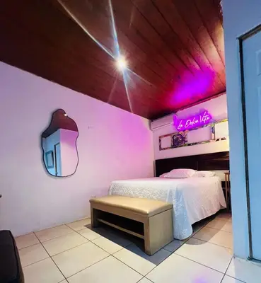 a bedroom with a bed with a neon sign on the wall at VILLA NAPOLI in Santa Ana