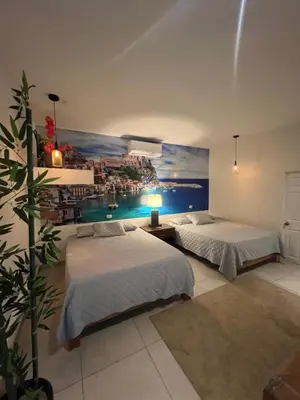 a bedroom with two beds and a painting on the wall at VILLA NAPOLI in Santa Ana
