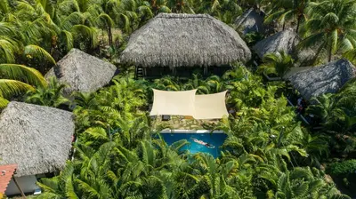 an aerial view of a resort with a pool and a straw hut at Hotel Martinez in Conchagüita