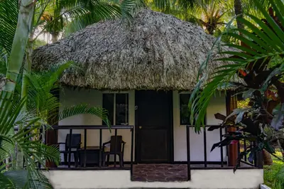 a small house with a thatch roof at Hotel Martinez in Conchagüita