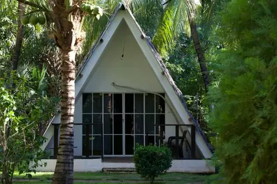 a small house with a large window and trees at Hotel Martinez in Conchagüita