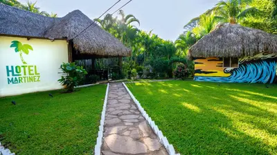 a resort with a grassy yard next to a building at Hotel Martinez in Conchagüita