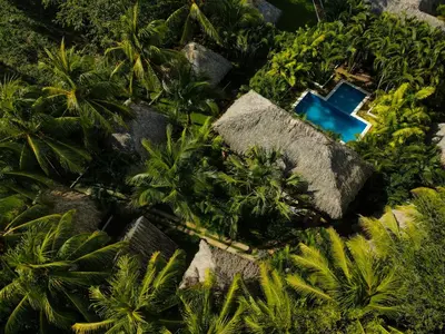 an overhead view of a house with a pool in the trees at Hotel Martinez in Conchagüita