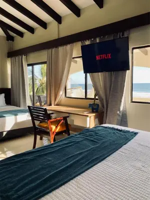 a hotel room with a bed and a sign that reads netflix at Vista Las Olas Resort in El Cuco