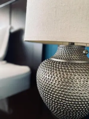 a close up of a silver lamp with a lamp shade at Vista Las Olas Resort in El Cuco