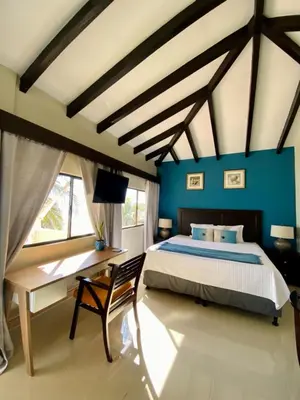 a bedroom with blue walls and a bed and a desk at Vista Las Olas Resort in El Cuco