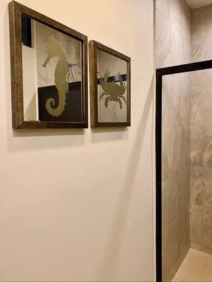 two framed pictures of a dragon on a wall in a bathroom at Vista Las Olas Resort in El Cuco