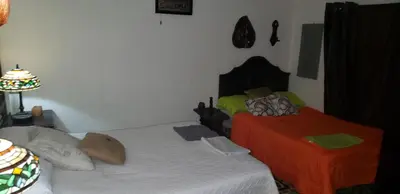 a bedroom with two beds and a lamp at Mendoza’s Guest House in Santa Ana