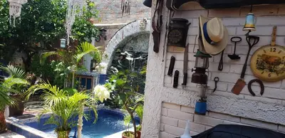 a wall with a swimming pool and clocks and plants at Mendoza’s Guest House in Santa Ana