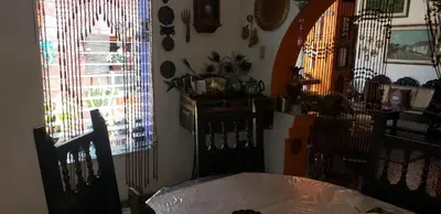 a dining room with a table and two windows at Mendoza’s Guest House in Santa Ana