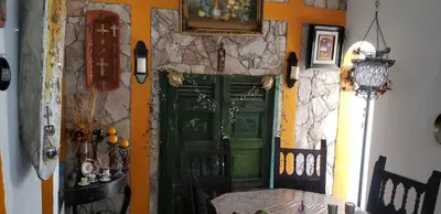 a green door in a room with a stone wall at Mendoza’s Guest House in Santa Ana