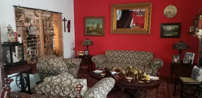 a living room with red walls and couches and a table at Mendoza’s Guest House in Santa Ana