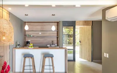 a kitchen with a white island with two bar stools at Fishermans Resort Life in La Libertad