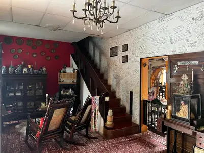 a room with a staircase with chairs and a chandelier at Mendoza’s GUESTHOUSE in Santa Ana