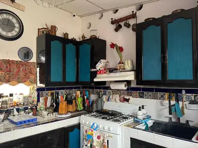 a kitchen with blue cabinets and a stove top oven at Mendoza’s GUESTHOUSE in Santa Ana