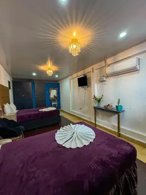 a room with a purple bed with a white umbrella on it at Hotel Brunette in Santa Ana