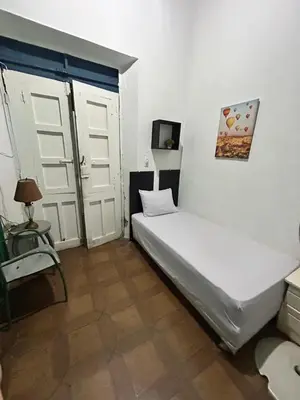 a bedroom with a white bed and two doors at Hotel Brunette in Santa Ana