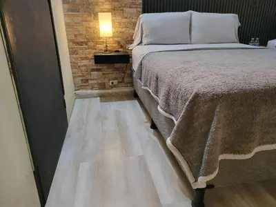 a bedroom with a bed and a brick wall at Green life in San Salvador