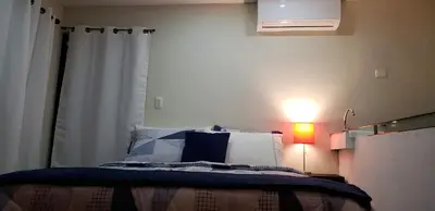 a bedroom with a bed with a lamp and a curtain at Green life in San Salvador