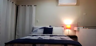 a bedroom with a bed with a curtain and a lamp at Green life in San Salvador