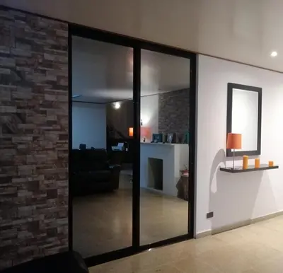 a living room with glass doors and a brick wall at Green life in San Salvador