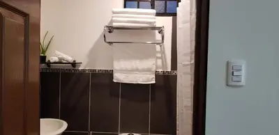 a bathroom with a towel rack and a sink at Green life in San Salvador