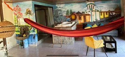 a hammock in a room with a train mural at Boutike Art & Wellness in Concepción de Ataco