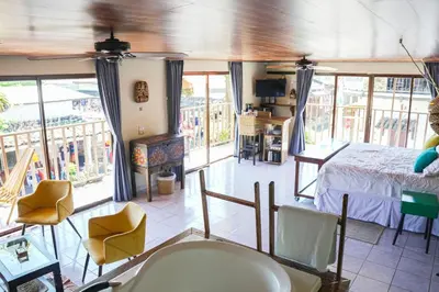 a living room with a bed and a balcony at Boutike Art & Wellness in Concepción de Ataco