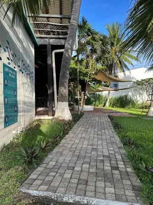 a brick walkway next to a building with palm trees at Lali Beach Hotel Boutique in Sonsonate