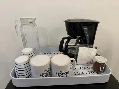 a tray with cups and a coffee maker on a table at Lali Beach Hotel Boutique in Sonsonate