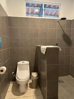 a bathroom with a toilet and a window at Lali Beach Hotel Boutique in Sonsonate