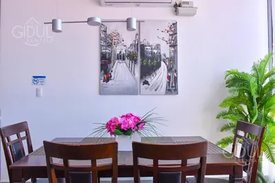 a dining room table with a vase of flowers on it at Volcano Views Apartment in San Salvador