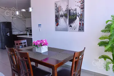 a dining room table and chairs with flowers on it at Volcano Views Apartment in San Salvador