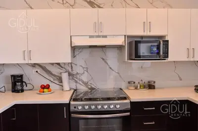 a kitchen with a stove and a microwave at Volcano Views Apartment in San Salvador