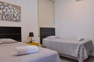a bedroom with two beds and a painting on the wall at Volcano Views Apartment in San Salvador