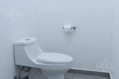 a white toilet in a bathroom with a white wall at Volcano Views Apartment in San Salvador