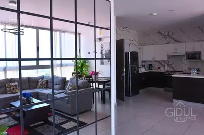 a kitchen and a living room with a couch and a table at Volcano Views Apartment in San Salvador