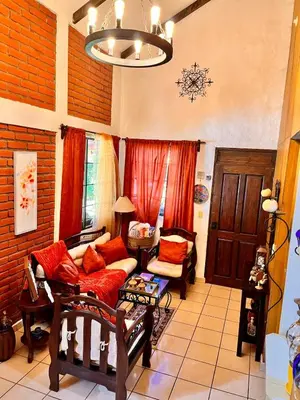a living room with a couch and a chandelier at Casa Heidi, Apaneca in Apaneca