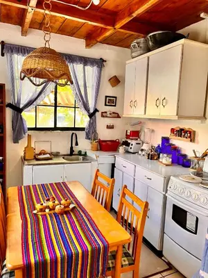 a kitchen with a table with a colorful table cloth at Casa Heidi, Apaneca in Apaneca